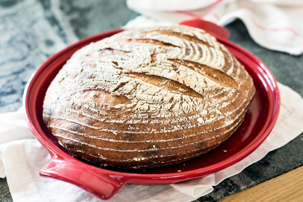 Freshly baked organic sourdough bread in a red dutch oven