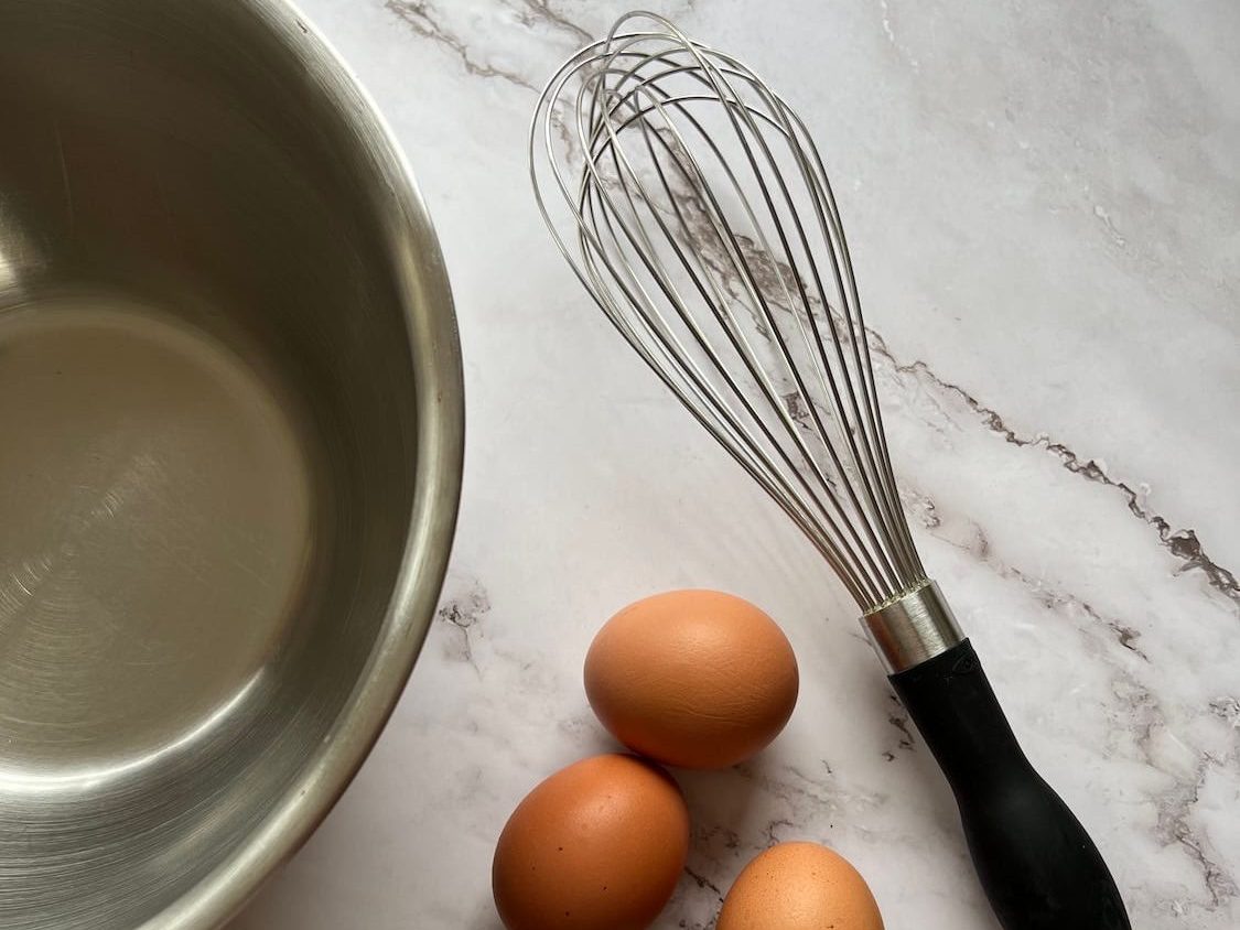 Mixing bowl with whisk and eggs